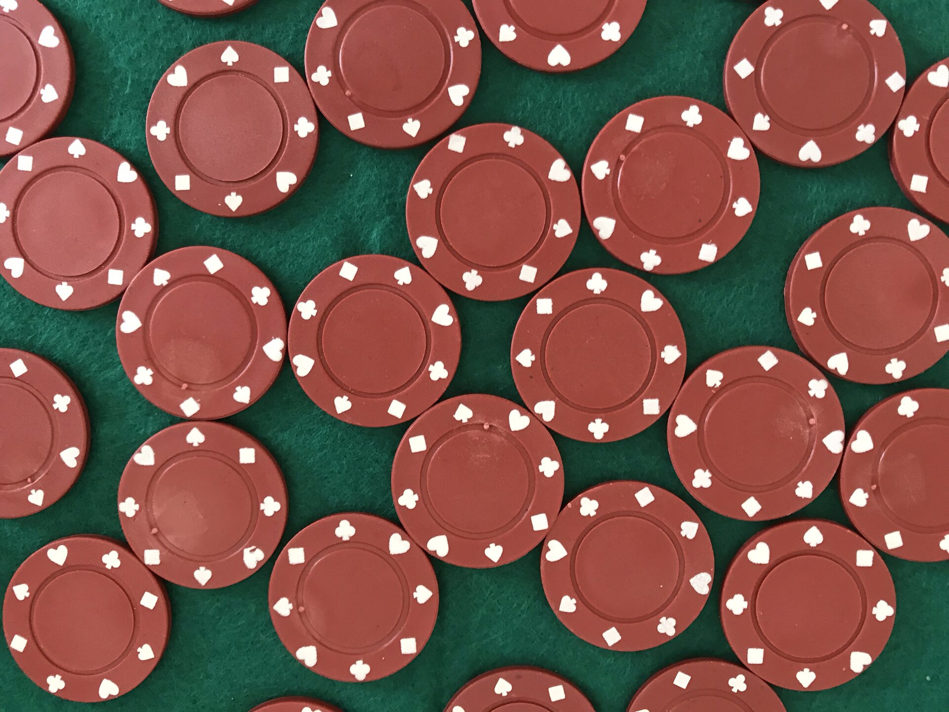 Montones de fichas de distintos colores sobre el tapete de una mesa de juego.